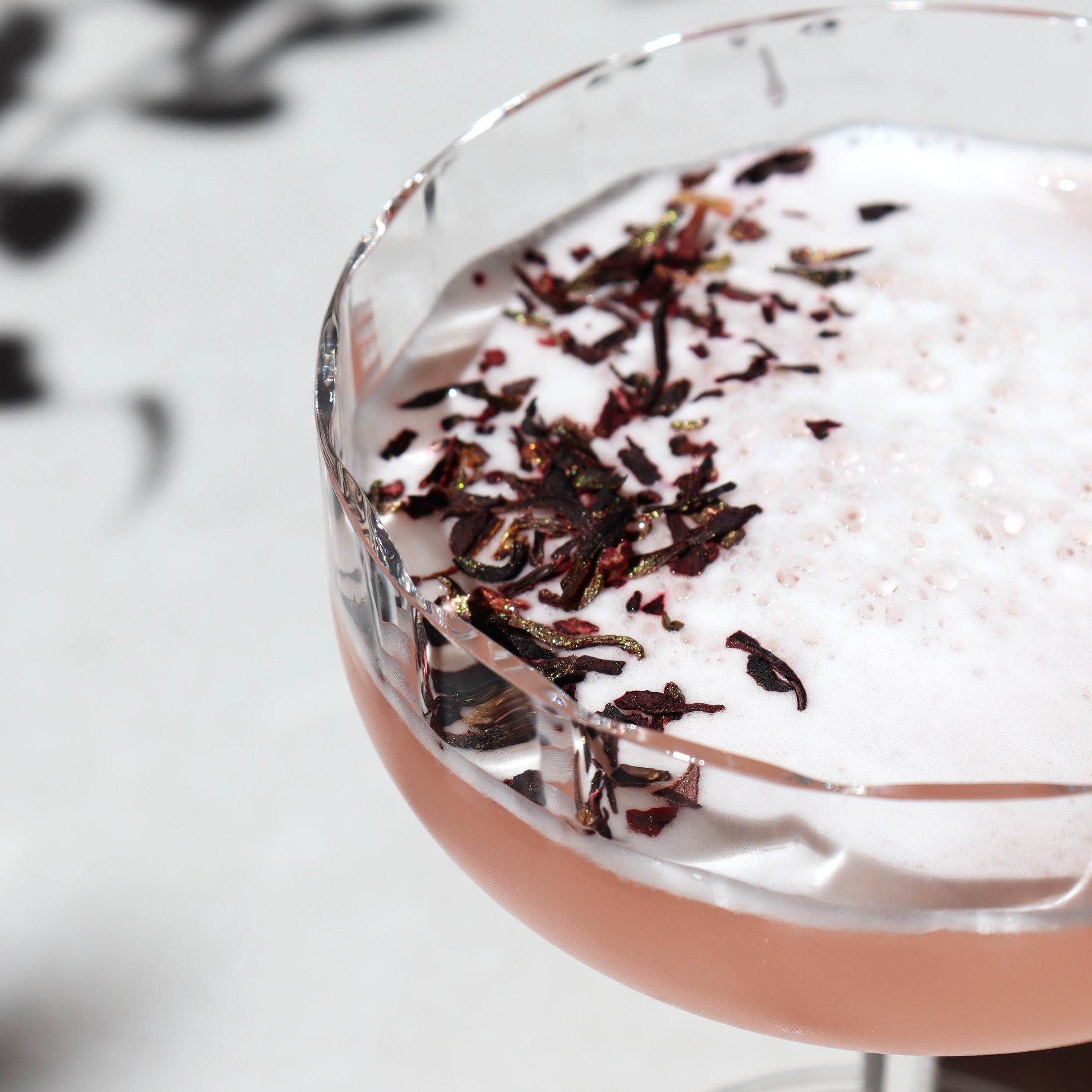 cocktail garnished with shimmering hibiscus 