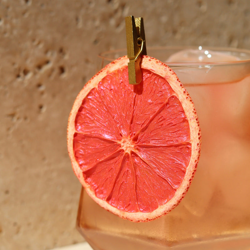Dehydrated Orange slice attached with a cocktail pin on a glass 